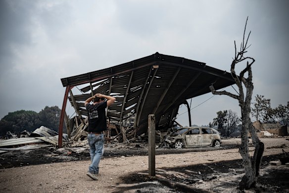 A resident inspects the damage in a burnt residential area following a wildfire in Le Porge, south-western France, on the weekend.