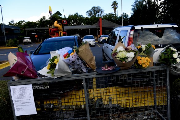 Flowers left at the car park in the McDonald’s in Queen Street, Campbelltown, where a paramedic was stabbed to death on Friday morning.