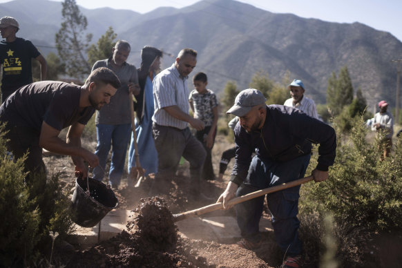 People dig a grave to bury bodies of victims of the earthquake in a village near Marrakesh.