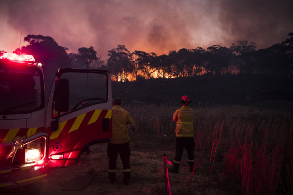 Rural Fire Service (RFS) firefighters monitor a bushfire that began with a hazard reduction burn near Oxford Falls on Saturday.