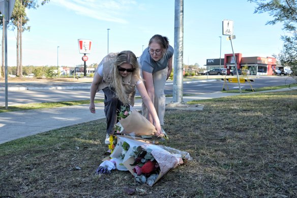 Odessa Sarnelli (right) and Georgie Bainbridge leave flowers near the scene of the crash.