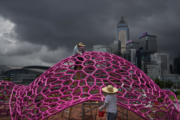 Workers wearing face masks paint an art installation in a Hong Kong park ahead of celebrations of the 25th anniversary of the handover to China.