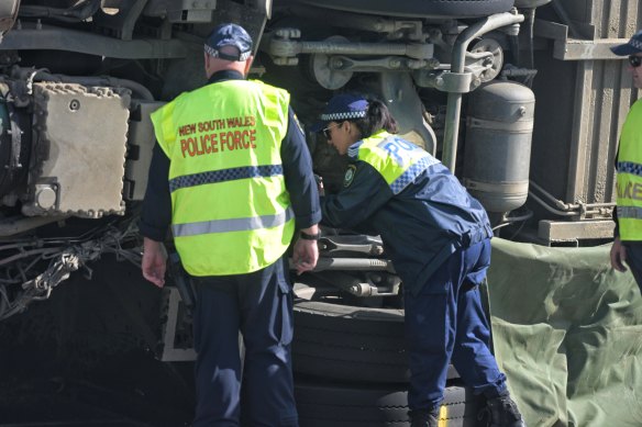 Police inspect the undercarriage of the bus.