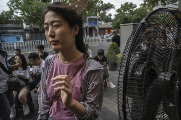 A woman cools herself in front of a misting fan in Beijing, China, on June 23.