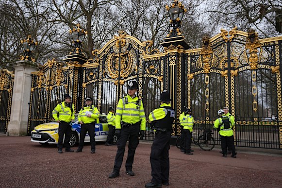 Police officers guard a gate at Buckingham Palace in London on Friday.