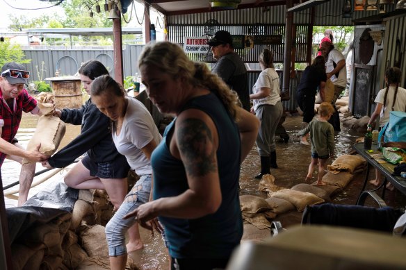 Friends and family of Dick Sharkey help protect his Forbes home from flooding.