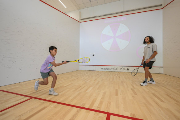 Matthew Lawlor and his son Easton, eight, play interactive squash at the Victorian Racket Club in Knoxfield.