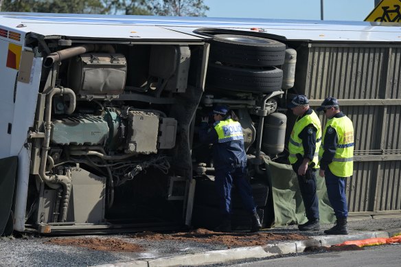 Police inspect the bus at the crash scene on Monday.