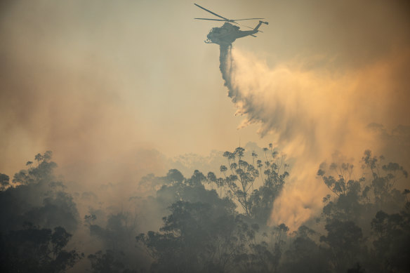 A helicopter drops water on the Wallacia fire near Sydney’s south-west.