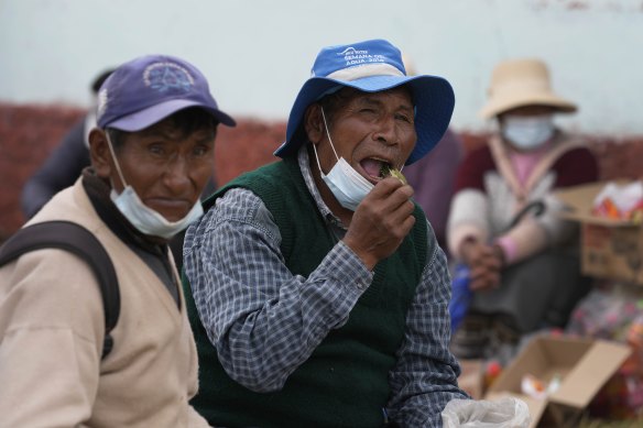 Residents eats coca leaves during a community meeting in Mijane, Peru