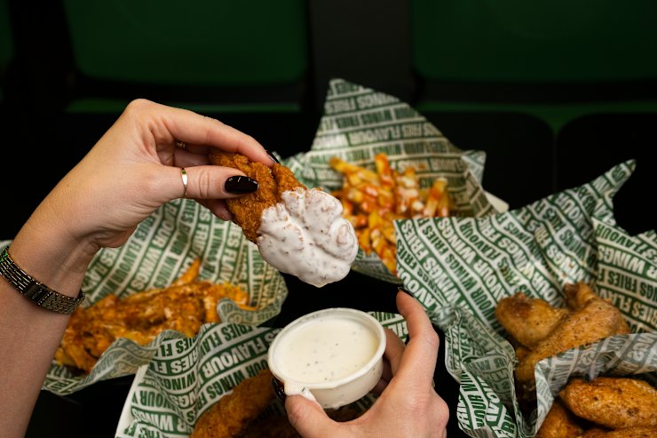Hot honey tenders being dipped into ranch sauce