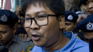 Reuters journalist Wa Lone is escorted by police from the court Wednesday outisde of Yangon, Myanmar. 