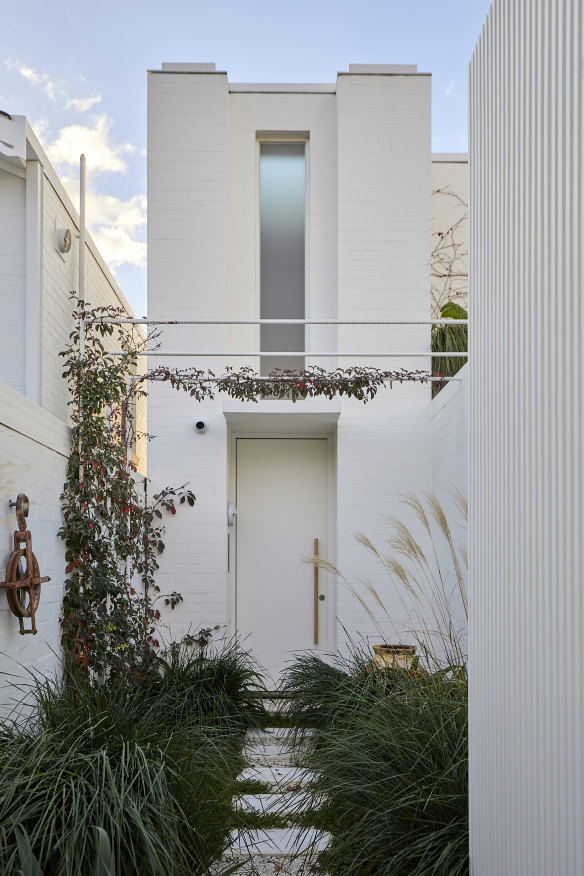 Entry from the street is via a private garden path flanked by two grasses and a pergola that will eventually be covered with silver vein creeper.