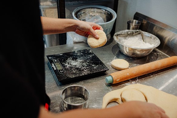 Filled doughnuts being cut and weighed. 