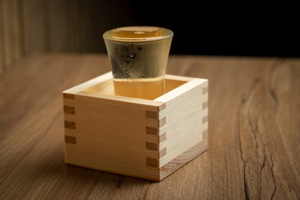 The sake overflows into its box.