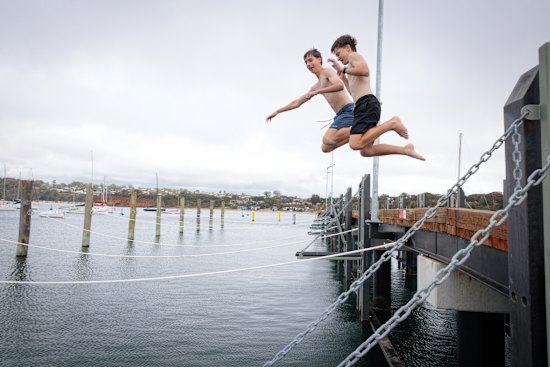Boys jump off Mornington Pier.