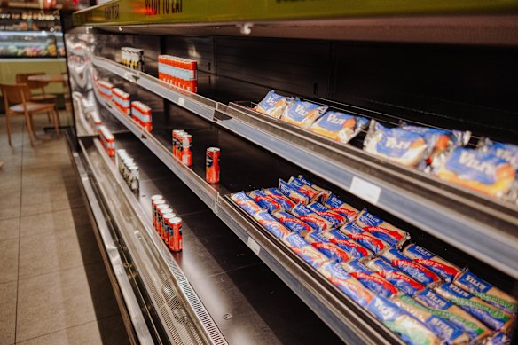 Partially emptied shelves with meat pies and sausage rolls.