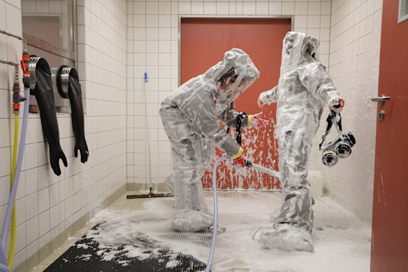 Nurses Louise and Ursula, dressed in personal protective equipment, spray each other down with a disinfectant foam while demonstrating protocols for dealing with infected patients at the Department of Infectious Diseases and Critical Care Medicine at Charite Hospital in Germany. The Charite department recently treated American doctor Peter Stafford, who survived his infection with ebola that he had contracted in the Democratic Republic of Congo.