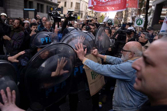 Retirees scuffle with police during a protest against a possible presidential veto of a bill passed by Congress to raise the minimum retirement pension, outside the presidential palace in Buenos Aires, Argentina.