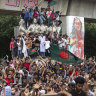 Protesters climb a public monument in Dhaka as they celebrate the news of Prime Minister Sheikh Hasina’s resignation.