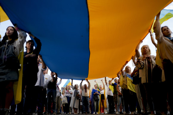 People hold a Ukrainian flag in Buenos Aires, Argentina on Saturday to mark the second anniversary of Russia’s invasion of Ukraine.