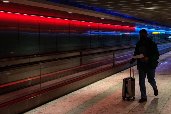 An airline passenger walks through an underpass between terminal buildings at Heathrow Airport on in London, England. 