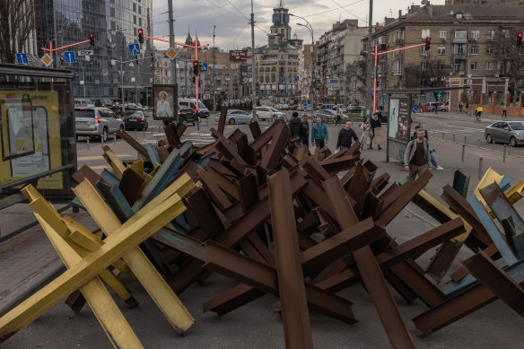 Locals walk past metal anti-tank barriers known as “hedgehogs” last month in downtown Kyiv, Ukraine.