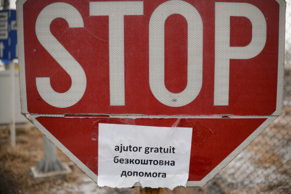 A poster with a text that reads “Free Help” is glued to a Stop sign at the Romanian-Ukrainian border, in Siret, Romania.