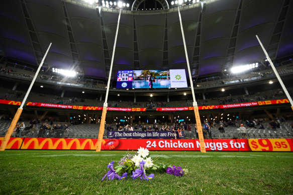 Flowers are laid for Cam McCarthy by Nat Fyfe and Alex Pearce.