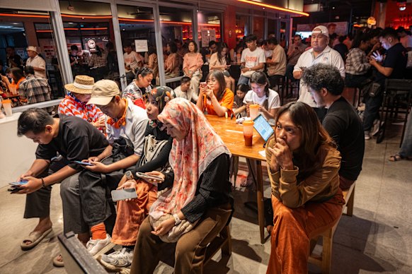 People’s Party supporters watch the vote count unfold.