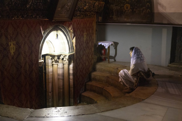  A worshipper prays next to the grotto believed to be the spot where Jesus was born at the Church of Nativity. Bethlehem was quiet last year and is expected to be even quieter this year due to the war in Gaza.