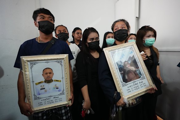 I parenti tengono in mano i ritratti del marito Suvitcha Sirisalung e della moglie Namthip Tubsuk, morti nell'incendio.
