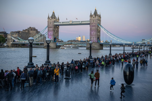 People wait as the pass the Tower Bridge.