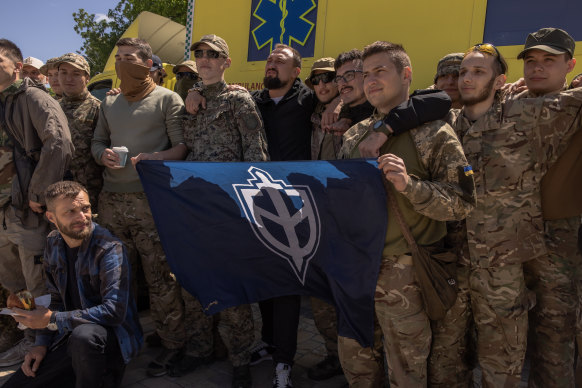 Ukrayna tarafında savaşan Rus hükümet karşıtı grup Rus Gönüllü Kolordu üyeleri, diğerleriyle fotoğraf çektirmek için poz veriyor.