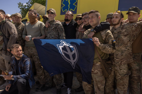 Members of The Russian Volunteer Corps, the Russian anti-government group that is fighting on Ukraine’s side, with others pose for photos.