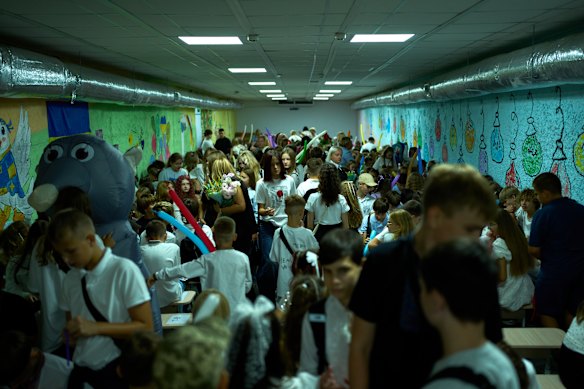 Children, parents and teachers huddle in an air raid shelter on the first day of the new school year.