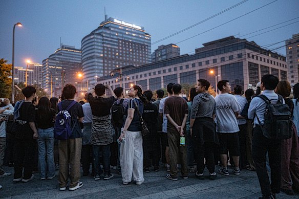 People gather to see the motorcade of US President Donald Trump outside the Four Seasons Hotel in Beijing.