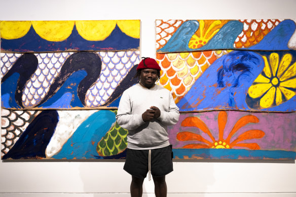 Alvaro Barrington in front of his paintings <i>Sea to C: sydney june</i> and <i>Sydney june victoria sunset</i>.