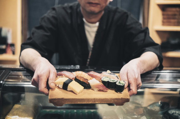 A sushi chef working in a small shop in Tokyo, Japan.