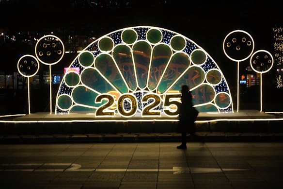 A woman walks near an illuminated decoration on New Year’s Eve in Seoul, South Korea.