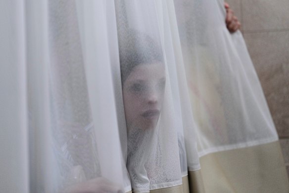 A mourner looks trough a curtain during the funeral of Levi Yitzhak Pash, who was killed along with five other Israelis in a shooting attack by two Palestinian gunmen at a bus stop in Jerusalem.