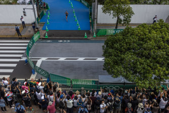 There was even a crowd: Spectators cheer and photograph a competitor in the triathlon relay in Tokyo on Saturday.