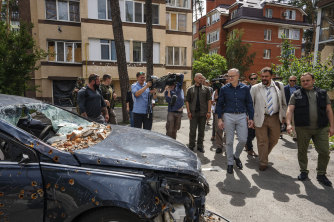 Australian Prime Minister Anthony Albanese looks at apartment buildings and vehicles damaged by Russian shelling in Irpin.