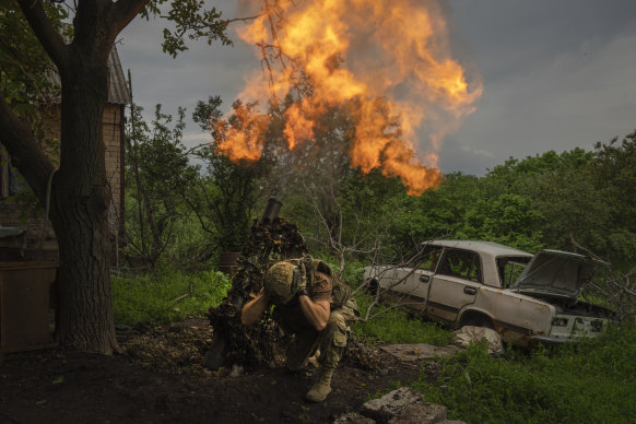 Ukraynalı bir asker, Bakhmut yakınlarındaki cephe hattındaki Rus mevzilerine havan topu atıyor.