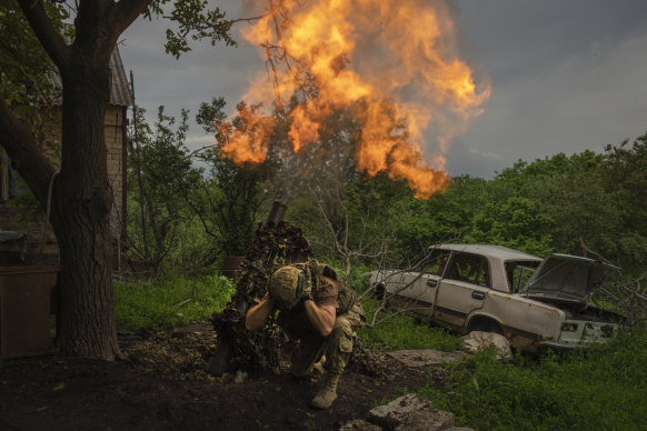 A Ukrainian soldier fires a mortar at Russian positions on the frontline near Bakhmut.