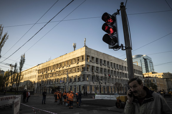 A new traffic light is seen as men repair the street left by a missile strike the day before near Taras Shevchenko National University in Kyiv, Ukraine. 