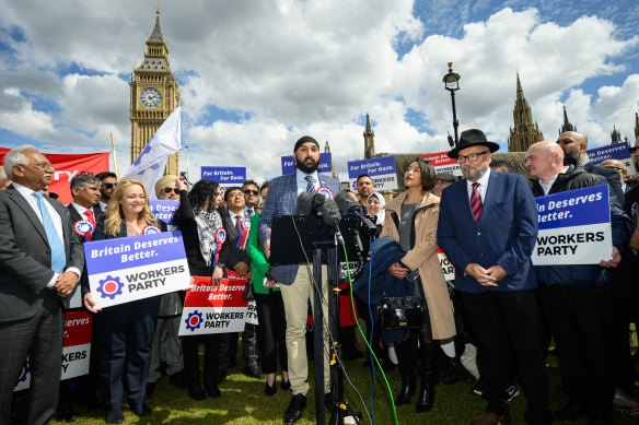 Leader of the Workers Party of Britain George Galloway (right) looks on as former England cricketer Monty Panesar (centre) addresses fellow party candidates in Parliament Square.
