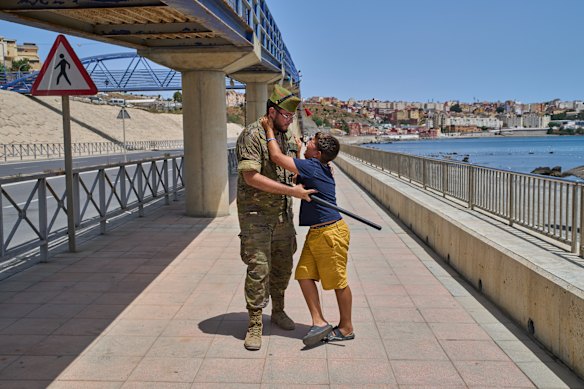 A 12-year-old who crossed into Spain is escorted by a Spanish soldier to the Spain-Morocco border this week, as the child begs not to be sent back to Morocco.