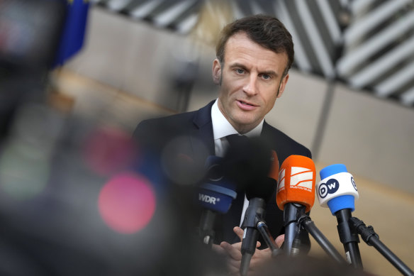 French President Emmanuel Macron speaks with the media as he arrives for an EU summit in Brussels.