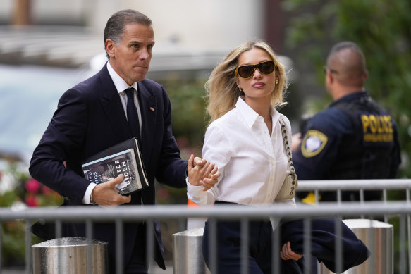 Hunter Biden, holding a copy of his memoir, arrives at the court with his wife, Melissa Cohen Biden.